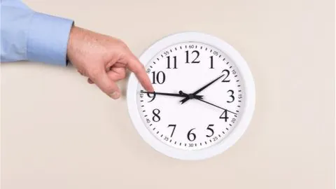 Someone physically turns back a clock