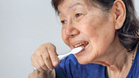 Older woman brushing teeth