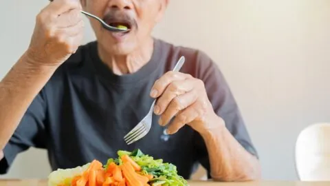 Older person eating vegetables